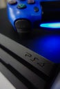 Sony black Playstation 4 Pro game console and blue wireless controller Royalty Free Stock Photo