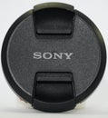 Sony Camera Lens Cap on white background. Branded cap of camera lens named Sony as accessories for those whose hobby in Royalty Free Stock Photo