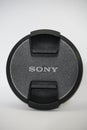 Sony Camera Lens Cap on white background. Branded cap of camera lens named Sony as accessories for those whose hobby in Royalty Free Stock Photo