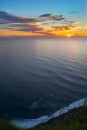 On a cliff watching sunset above the horizon Royalty Free Stock Photo