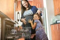 Soon mommy will have another little angel. Portrait of a daughter hugging her pregnant mother in the kitchen. Royalty Free Stock Photo