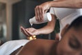 This soothing massage oil will work wonders. Closeup shot of a massage therapist pouring body oil into her hands while Royalty Free Stock Photo