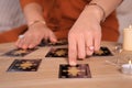 Soothsayer predicting future with tarot cards at table indoors, closeup Royalty Free Stock Photo