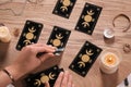 Soothsayer predicting future with tarot cards at wooden table, closeup Royalty Free Stock Photo
