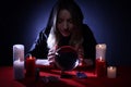 Soothsayer using crystal ball to predict future at table in darkness. Fortune telling Royalty Free Stock Photo