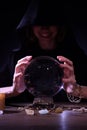 Soothsayer using crystal ball to predict future at table in darkness. Fortune telling Royalty Free Stock Photo