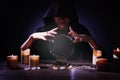 Soothsayer using crystal ball to predict future at table in darkness. Fortune telling Royalty Free Stock Photo