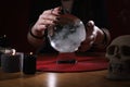 Soothsayer using crystal ball to predict future at table indoors, closeup Royalty Free Stock Photo