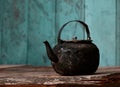 Sooty old teapot on old table in kitchen Royalty Free Stock Photo