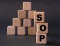 SOP - acronym on wooden cubes on a dark background