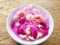 Sop Buah is mixed fruit with symple syrup, condensed milk and ice cubes. Served in bowl on wooden table background