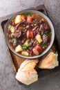 Sopa da Pedra traditional recipe combines red kidney beans, potatoes, cured meat and sausages closeup in the plate. Vertical top