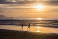 Sopelana Beach, Spain - August 16 2019: Two kids running and playing on an empty beach. Beautiful sunset in Basque Country, north Royalty Free Stock Photo