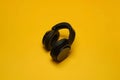 Sophisticated black wireless headphones on yellow