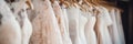 Sophisticated luxury bridal dresses on hangers in a white wedding gown boutique salon