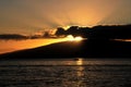 Sophisticated sunset in Maui Hawaii with sun rays and a small boat