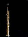 Soprano Sax, wind instrument saxophone staying on a black background, vertical, copy space Royalty Free Stock Photo