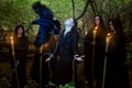 Sorcerers in black cloaks conduct a magical ritual over a man