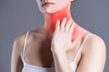 Sore throat, woman with pain in neck, gray background Royalty Free Stock Photo