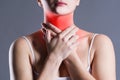 Sore throat, woman with pain in neck, gray background Royalty Free Stock Photo