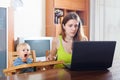 Sorehead mother with baby using laptop
