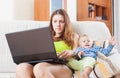 Sorehead mother with crying toddler working online