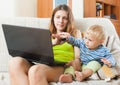 Sorehead woman with baby working with computer