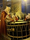 Soria, Spain - April 11, 2022: hooded brother playing the bass drum during the procession on Holy Monday in Holy Week