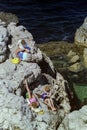 SORRENTO, ITALY, 1984 - Three blonde tourists relax in the sun on the rocks of the Baths of Queen Giovanna in Sorrento