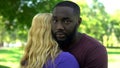 Sorrowful black man embraces beloved woman, clash of interests, misunderstanding