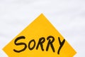 Sorry handwriting text close up isolated on orange paper with copy space. Writing text on memo post reminder Royalty Free Stock Photo