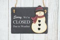 Sorry we`re Closed Due to weather sign on a hanging chalkboard with snowman Royalty Free Stock Photo