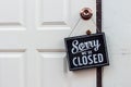 Sorry we\'re closed sign. grunge image hanging on a white door. Royalty Free Stock Photo