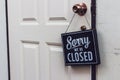 Sorry we\'re closed sign. grunge image hanging on a white door Royalty Free Stock Photo