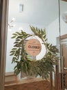 Sorry we're closed sign. wooden sign surrounded by the platns hanging on a glass door Royalty Free Stock Photo