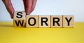 Sorry to worry. Hand turns a cube and changes the word `worry` to `sorry`. Beautiful yellow table, white background. Business Royalty Free Stock Photo