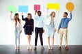 Sorry, what did you say. a group of work colleagues standing next to each other while holding speech bubbles against a