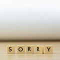 Sorry word written in cube on wooden floor on white background