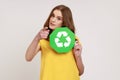 Sort your rubbish. Confident teenager girl in yellow casual style t-shirt holding recycling sign