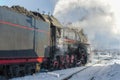 Locomotive driver looks out of the booth of the old Soviet steam locomotive