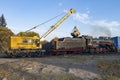 Railway crane KZh-462 `Pervomaets` loads with coal the old soviet steam locomotive