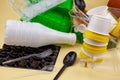 Sorting garbage. Plastic waste for recycling. Plastic bottles, containers, forks, spoons, egg packaging, caps. Yellow background