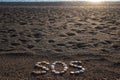 SOS message made with stones on the beach Royalty Free Stock Photo