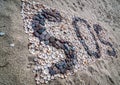 SOS message on the beach with stones and shells Royalty Free Stock Photo