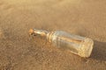 SOS message in glass bottle on sand, closeup Royalty Free Stock Photo