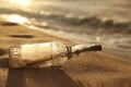 SOS message in glass bottle on sand near sea Royalty Free Stock Photo