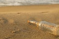 SOS message in glass bottle on sand near sea, space for text Royalty Free Stock Photo