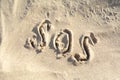 SOS message written on sandy beach outdoors, top view Royalty Free Stock Photo