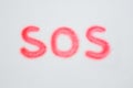 SOS painted with a finger in the snow Royalty Free Stock Photo