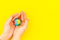 SOS Save the planet concept. The earth in hands on yellow background top view flat lay space for text